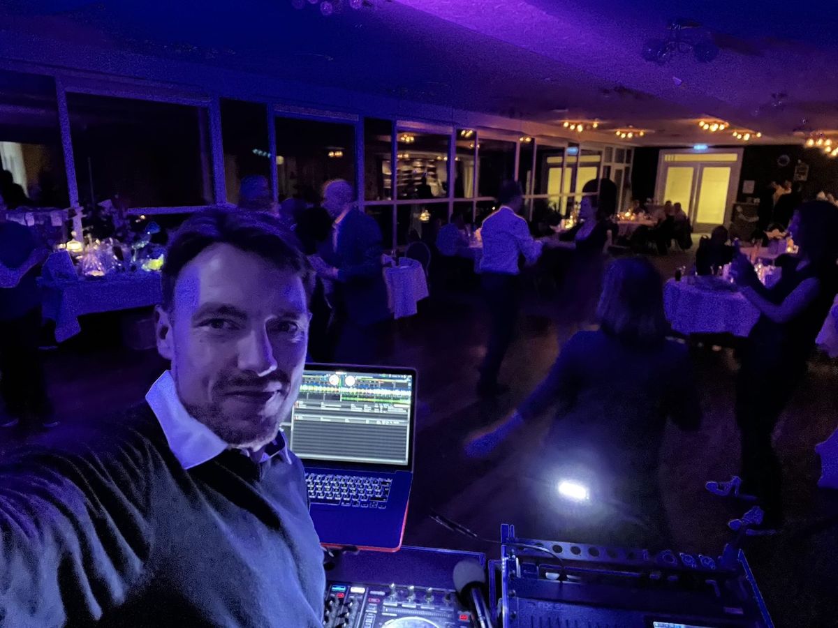 Dave Groth am DJ-Pult, im Hintergrund die Feier